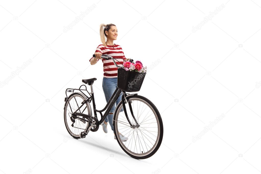 Full length portrait of a young woman pushing a bicycle isolated on white background