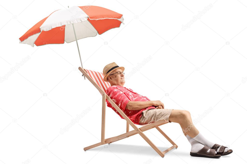 Elderly tourist sitting on a deck chair with an umbrella isolated on white background