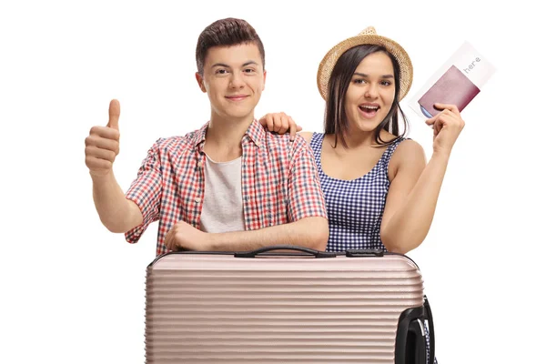 Teenage tourists with a passport and a suitcase making a thumb up sign isolated on white background