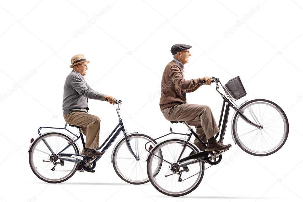 Seniors riding bicycles with one of them doing a wheelie isolated on white background