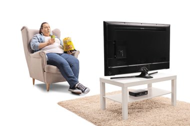 Cips ve içki bir koltukta oturan ve beyaz arka plan üzerinde izole televizyon izlerken bir çanta ile kadın kilolu