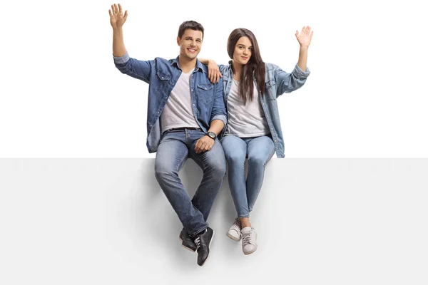 Young Couple Sitting Panel Waving Camera Isolated White Background — Stock Photo, Image