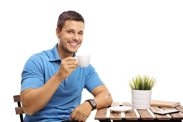 Joven Sosteniendo Una Taza Sentado Una Mesa Aislado Sobre Fondo — Foto de Stock