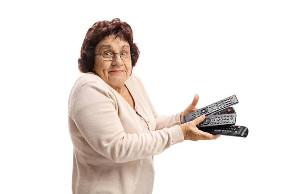 Confused Senior Lady Holding Bunch Remotes Isolated White Background — Stock Photo, Image