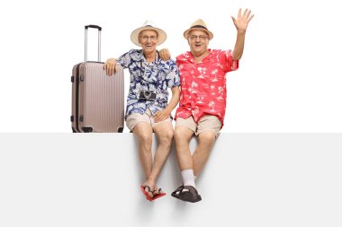 Beyaz arka plan üzerinde izole kamera onlardan biriyle bir panelde oturan yaşlı turistler sallayarak