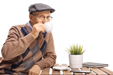 Bir kahve masada oturan ve bir fincan beyaz arka plan üzerinde izole içme olgun adam