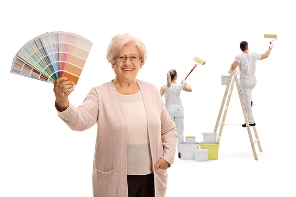 Mujer Madura Sosteniendo Una Muestra Color Con Dos Pintores Pintando —  Fotos de Stock