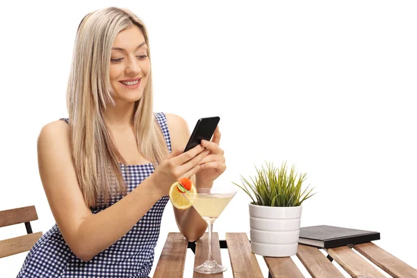 Mujer Joven Sentada Una Mesa Mirando Teléfono Aislado Sobre Fondo —  Fotos de Stock