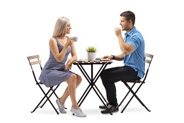 年轻女子和一个年轻男子坐在咖啡桌上的白色背景隔离 — 图库照片