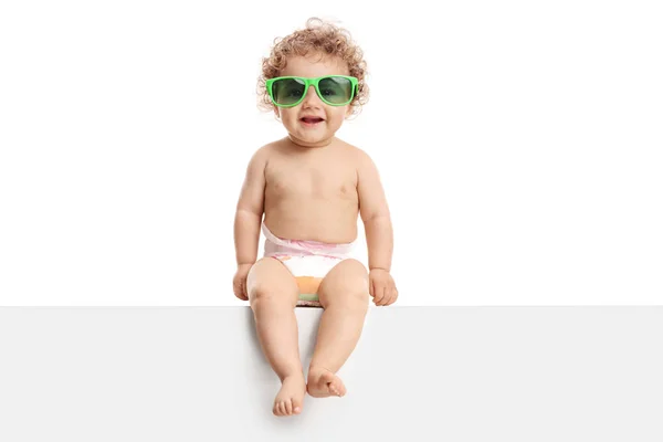 Schattig Babyjongen Met Een Paar Zonnebril Zitten Een Paneel Geïsoleerd — Stockfoto