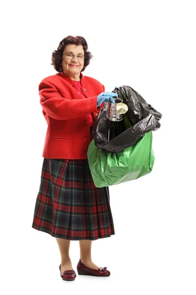 一个老妇人的全长画像投掷罐子罐头在被隔绝的垃圾袋在白色背景下 — 图库照片