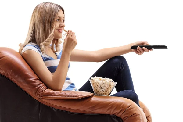 Νεαρή Γυναίκα Καθισμένη Μια Πολυθρόνα Μπροστά Στην Τηλεόραση Και Τρώγοντας — Φωτογραφία Αρχείου
