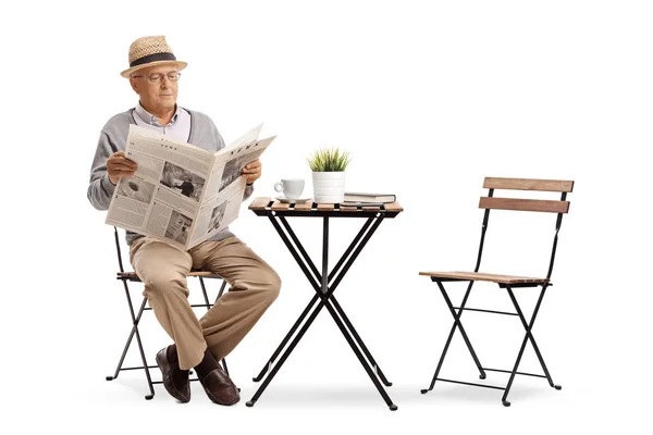 Senior Som Sitter Ett Soffbord Som Läser Tidning Som Isolerad — Stockfoto