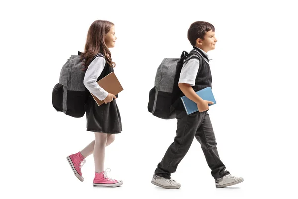 Schulmädchen Und Schuljunge Mit Rucksäcken Gehen Isoliert Auf Weißem Hintergrund — Stockfoto