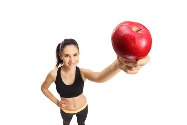 白い背景で隔離赤いリンゴを保持しているスポーツ ウエアで若い女性 — ストック写真