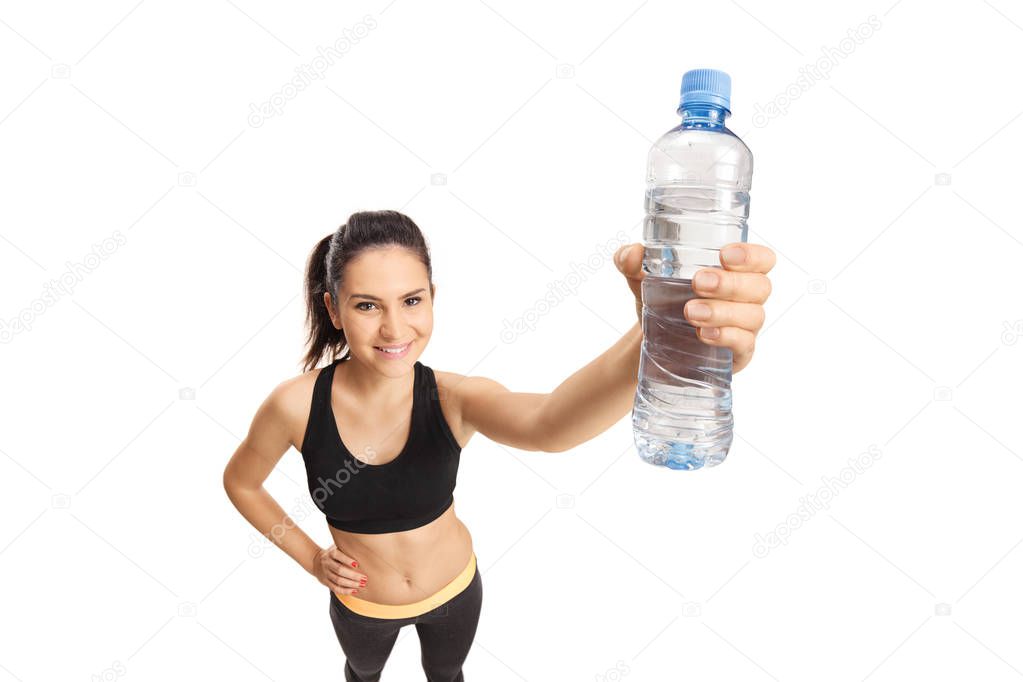 Young smiling female in sport clothing holding a botle of water isolated on white background