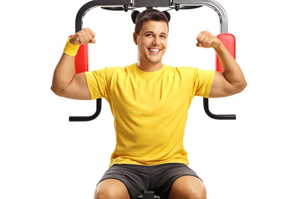 英俊的男子显示二头肌肌肉在一个独立于白色背景的健身机上 — 图库照片