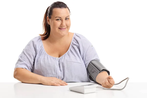 Übergewichtige Frau Misst Ihren Blutdruck Und Blickt Isoliert Die Kamera — Stockfoto