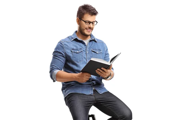 若い男が白い背景で隔離の本を読んで — ストック写真
