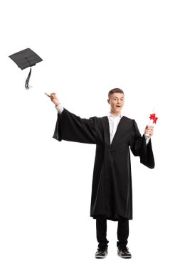 Bir yüksek lisans öğrencisi diplomasına tutarak ve beyaz arka plan üzerinde izole bir mezuniyet şapka atma tam uzunlukta portresi