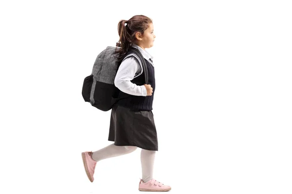 女子高生制服歩いて白い背景で隔離のバックパックの完全な長さのプロファイル — ストック写真