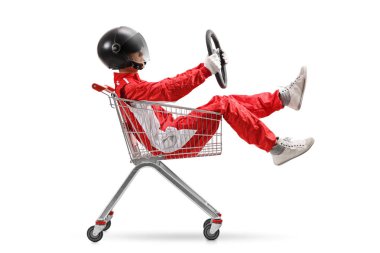 Guy in a racing suit with helmet holding a steering wheel and sitting inside a shopping cart isolated on white background clipart