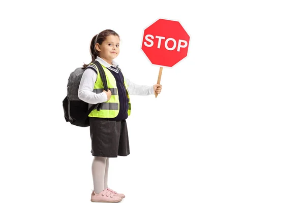 一時停止の標識と白い背景に対して安全ベストを着て小さな女子高生 — ストック写真