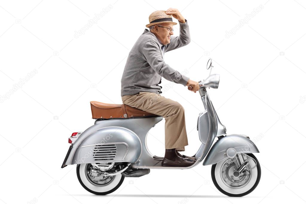 Full length profile shot of a gentleman riding a vintage motorbike isolated on white background