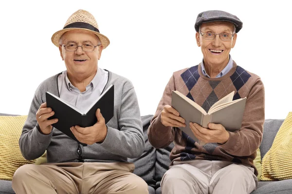 Dos Hombres Maduros Con Libros Sentados Sofá Aislados Sobre Fondo —  Fotos de Stock