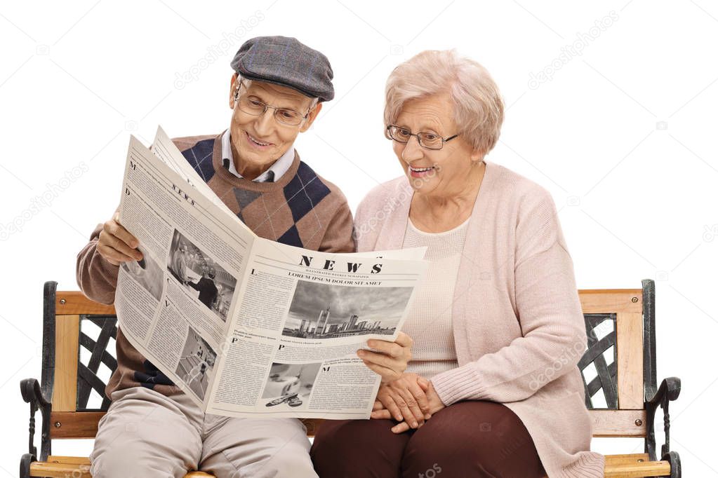 Elderly man and woman reading a newspaper together isolated on white background