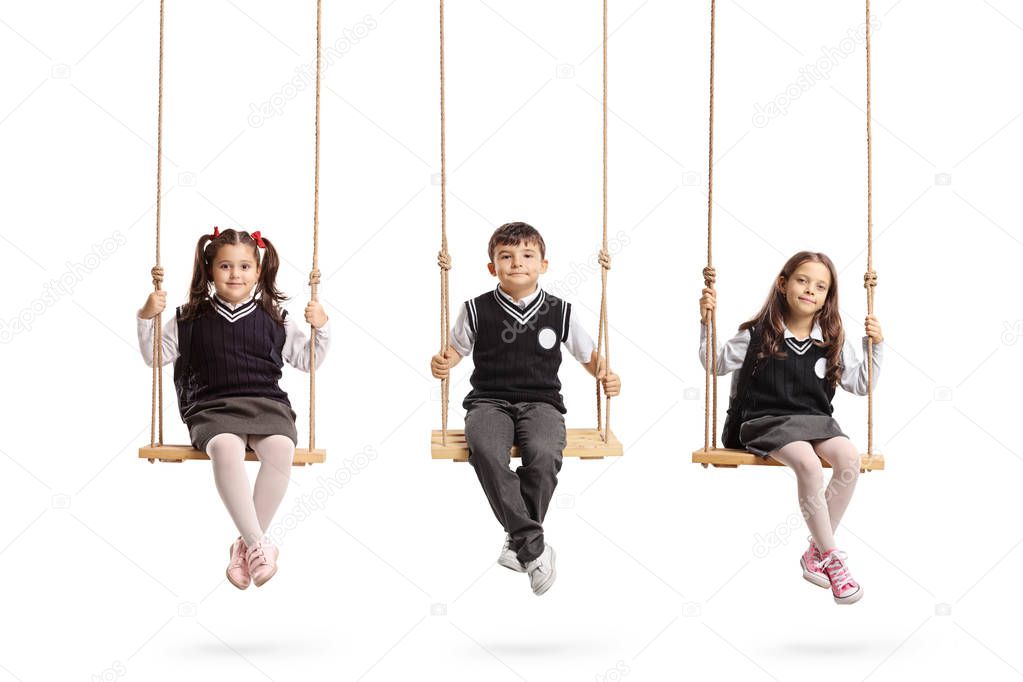 Schoolchildren sitting on wooden swings isolated on white background