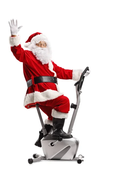 Noel Baba Bir Sabit Bisiklet Üzerinde Egzersiz Sallayarak Beyaz Arka — Stok fotoğraf