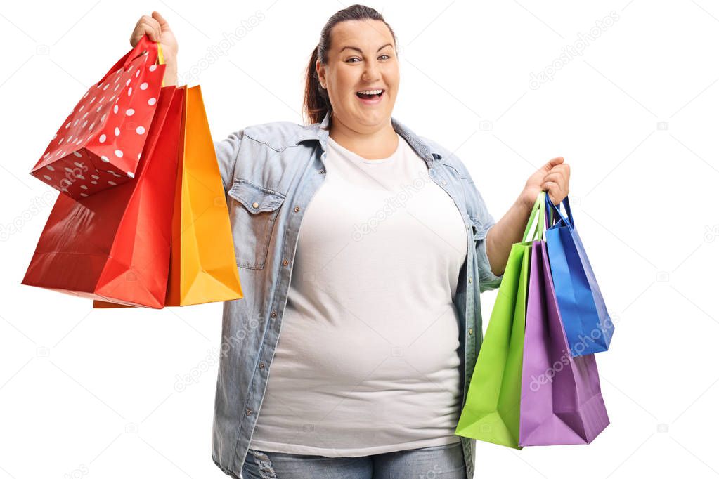 Happy plus size woman holding shopping bags isolated on white background