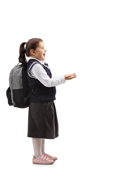 彼女の分離の白い背景の前に彼女の手を繋いで学校制服に驚いた少女の完全な長さのプロファイル ショット — ストック写真