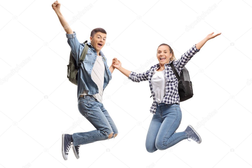 Happy male and female students jumping isolated on white background 