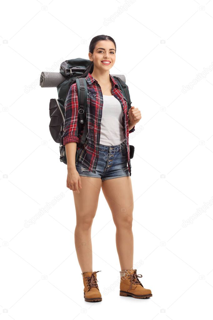 Female hiker with backpack standing and looking at the camera isolated on white background