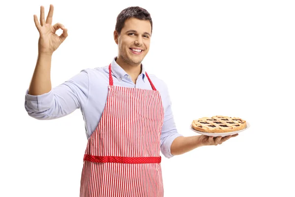 若い男のパイを保持していると 白い背景で隔離の手で完璧な身振りで示すこと — ストック写真