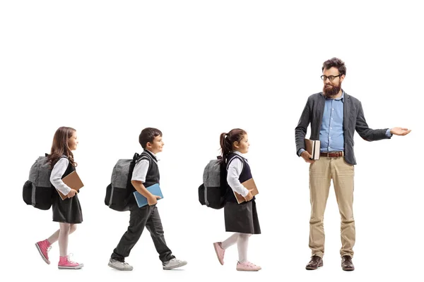 Full Length Profile Shot Schoolchildren Walking Line Teacher Gesturing Welcome — Stock Photo, Image