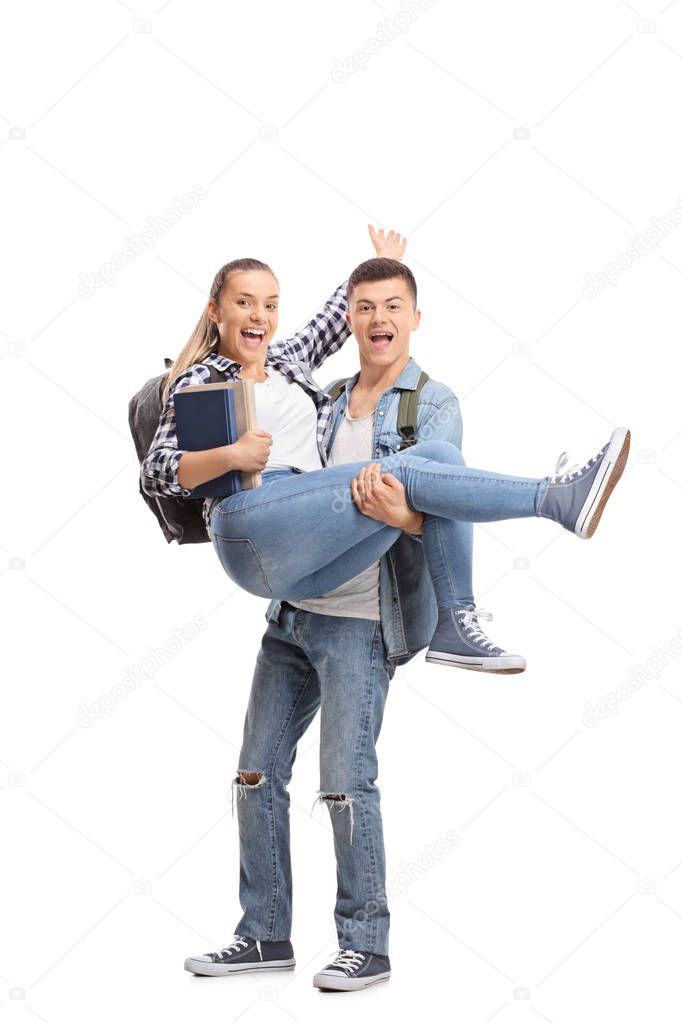 Full length portrait of a teenage boy carrying a girl in his hands isolated on white background