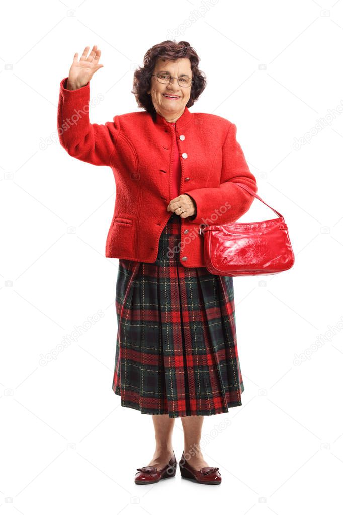 Full length portrait of a senior lady waving at the camera isolated on white background
