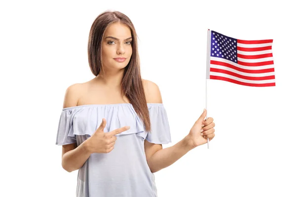 拿着美国国旗的年轻妇女和指向被隔绝的在白色背景 — 图库照片