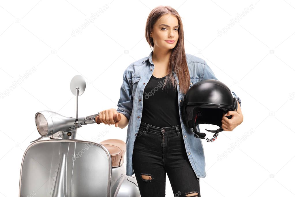 Young trendy female standing next to a scooter and holding a helmet isolated on white background