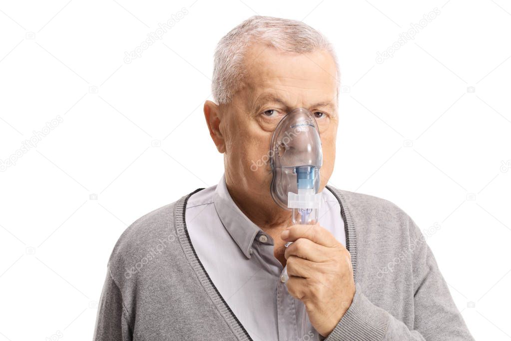 Elderly man inhaling with a mask isolated on white background