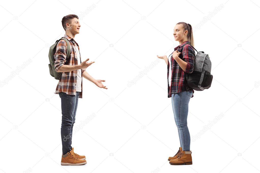 Full length profile shot of teenage students talking with each other isolated on white background