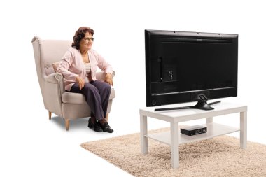 Bir koltukta oturan ve beyaz arka plan üzerinde izole televizyon izlerken üst düzey Bayan