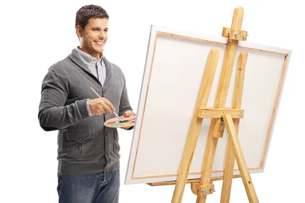 若い男は白い背景に分離されたキャンバスの絵画 — ストック写真
