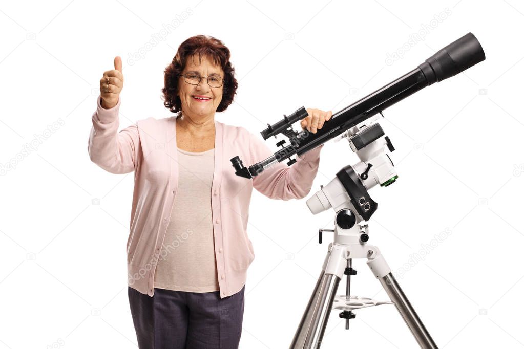 Elderly woman with a telescope looking at the camera and showing thumbs up isolated on white background