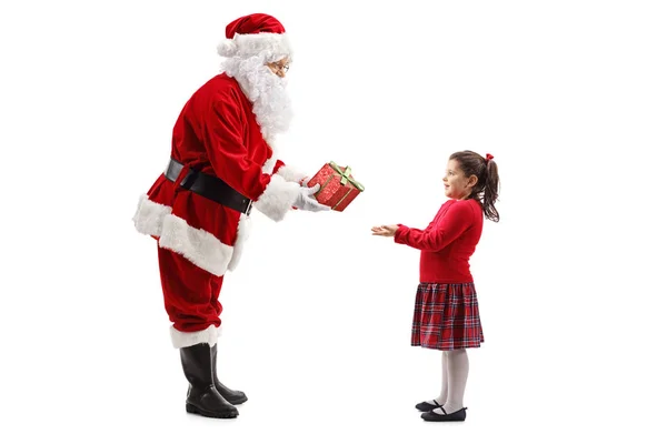 在白色背景查出的一个幸福的小女孩的礼物的圣诞老人的全长轮廓拍摄 — 图库照片