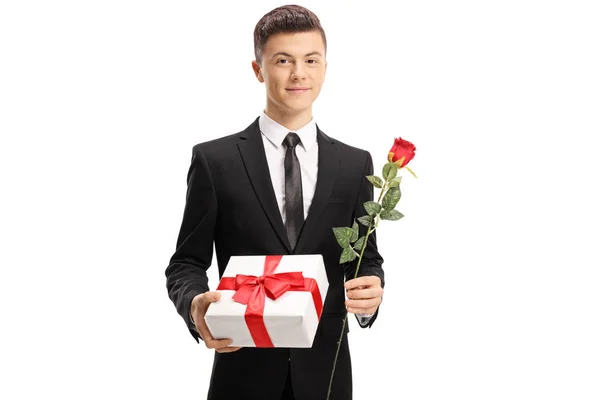 穿着优雅的英俊的十几岁的男孩拿着礼物和玫瑰孤立的白色背景 — 图库照片