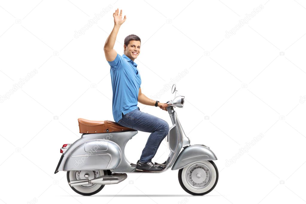 Full length shot of a young man riding a vintage scooter and waving isolated on white background